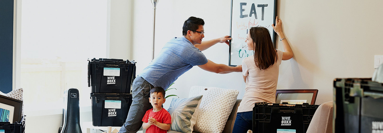 Young couple hanging artwork in living room