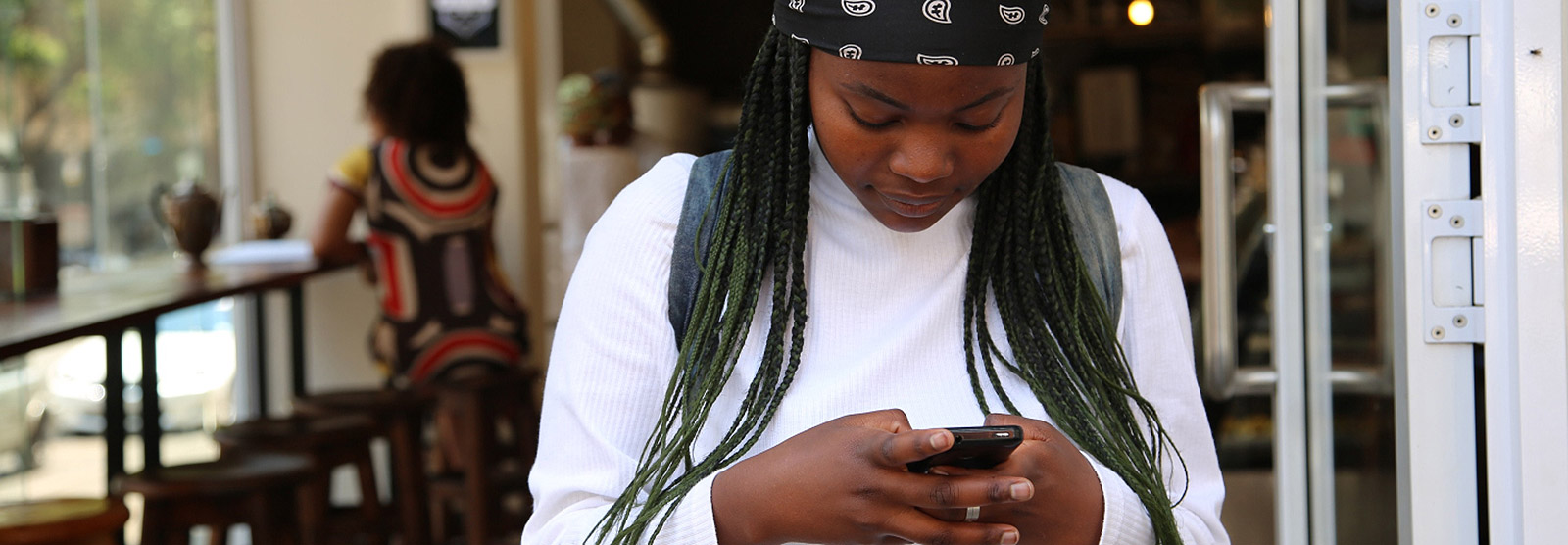 Young woman using phone in lobby